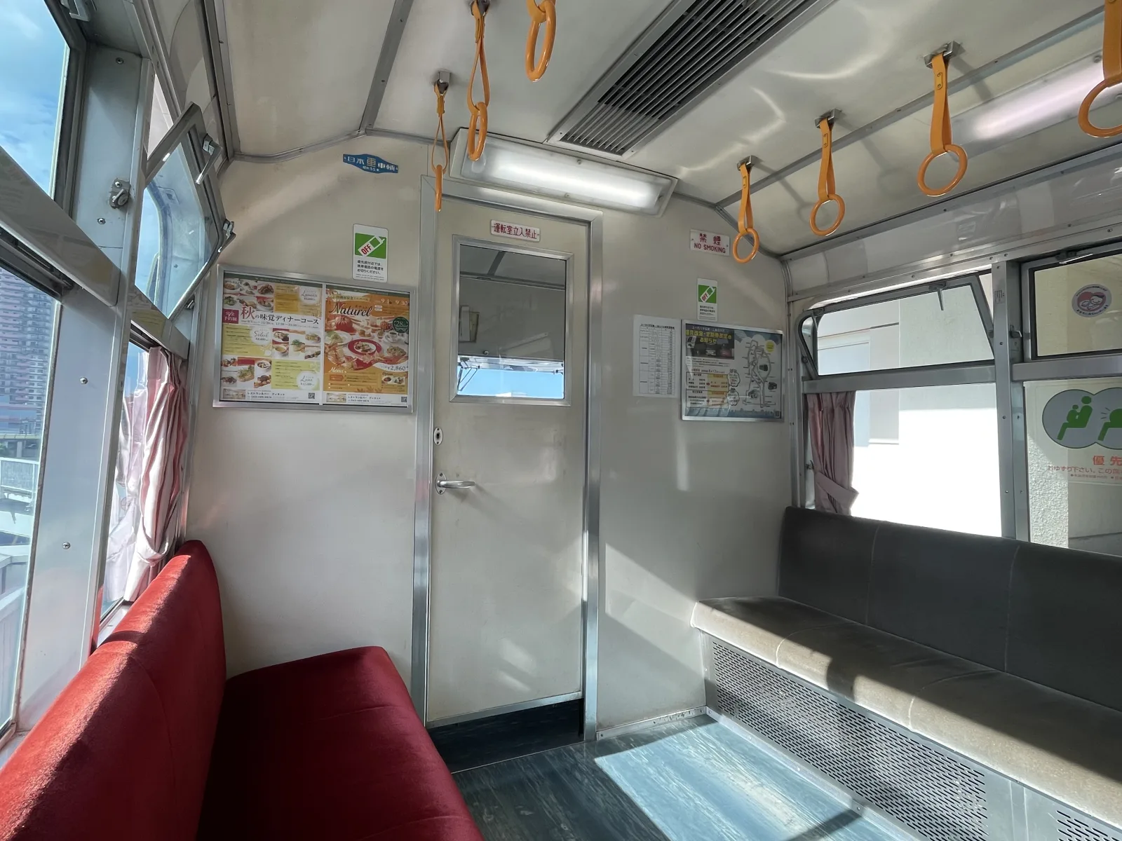 赤いロングシートが並ぶ山万ユーカリが丘線の車内